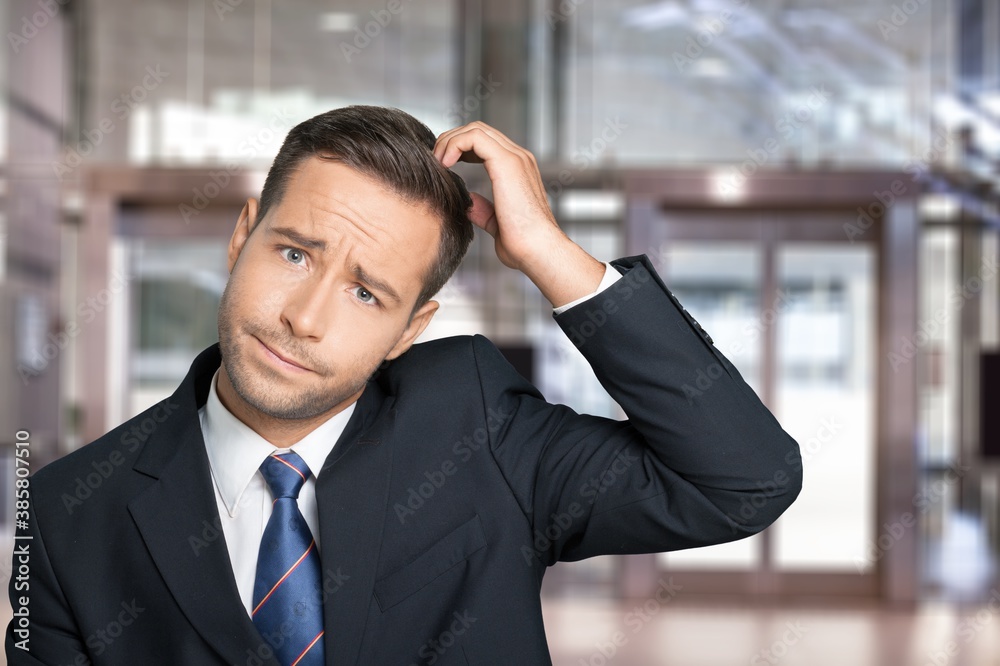 Young businessman scratching his head, hard decision