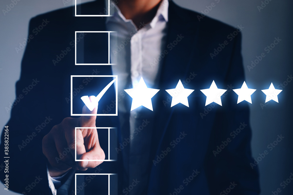 Male hand putting check mark a checkbox on five star rating. Increase rating  company concept.