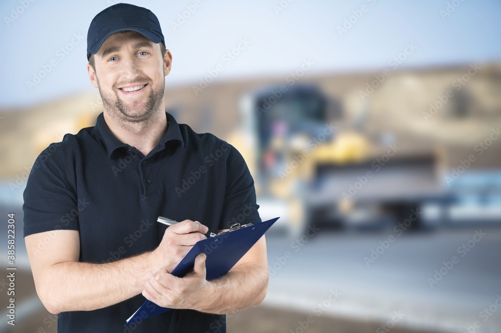 Delivery man with clipboard on outdoor background