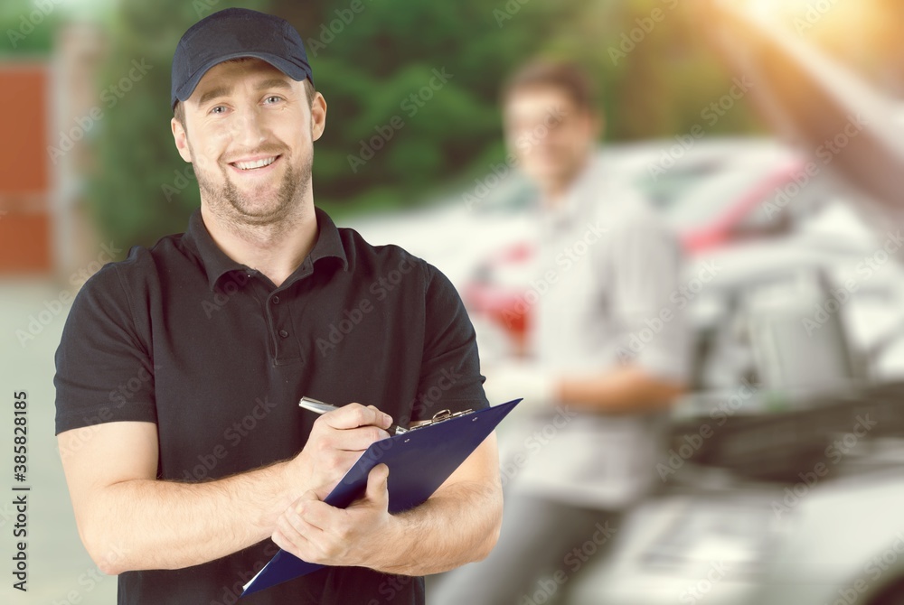 Delivery man with clipboard on outdoor background