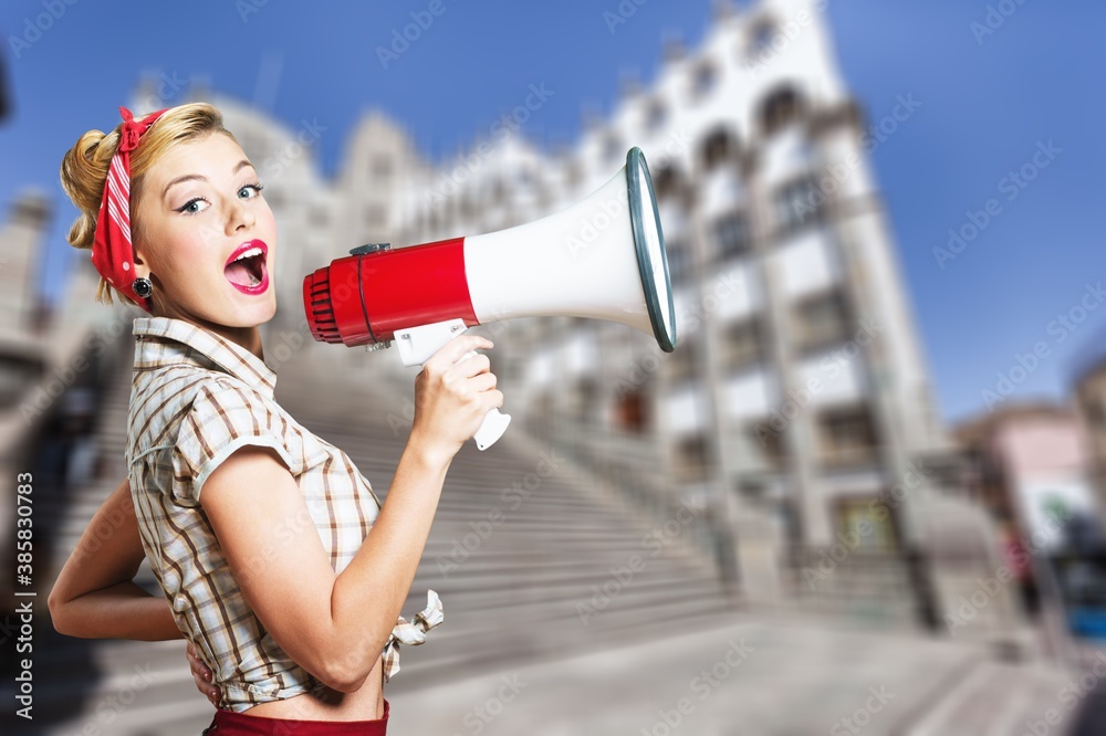 Beautiful woman holding megaphone and screams