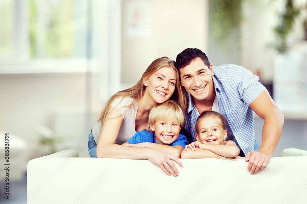 Beautiful smiling family in a room on couch