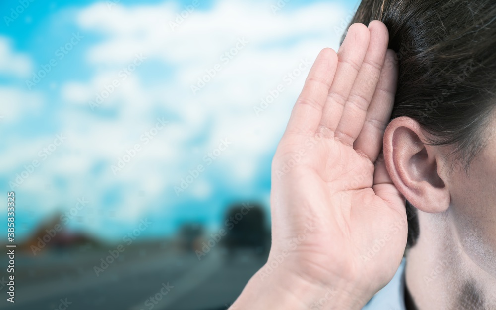 Human holds his hand near his ear and listening