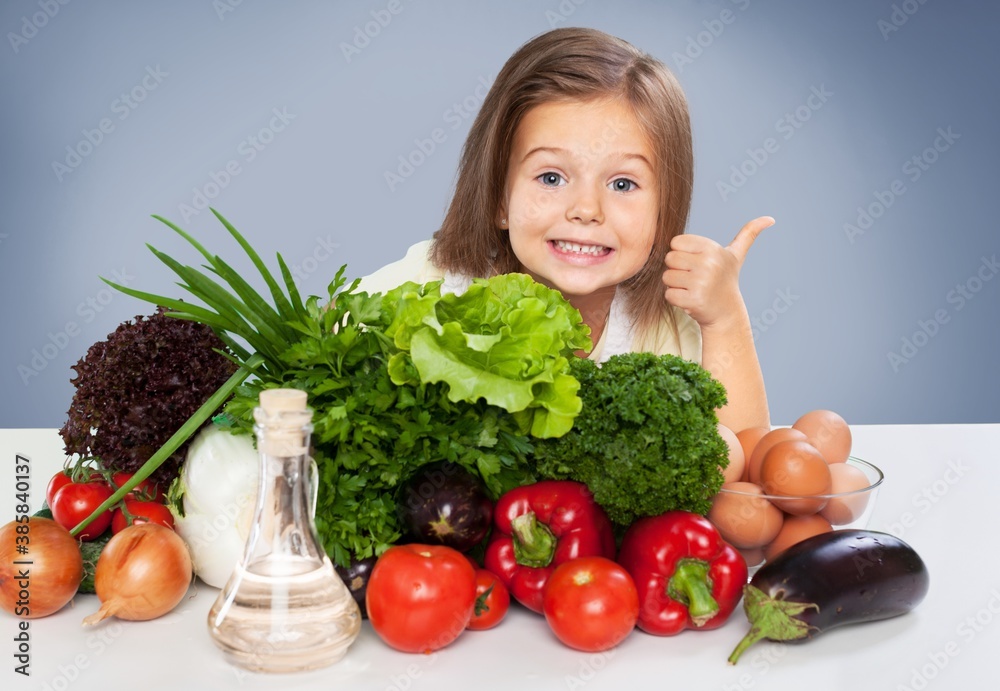 Little happy girl with raw vegetables