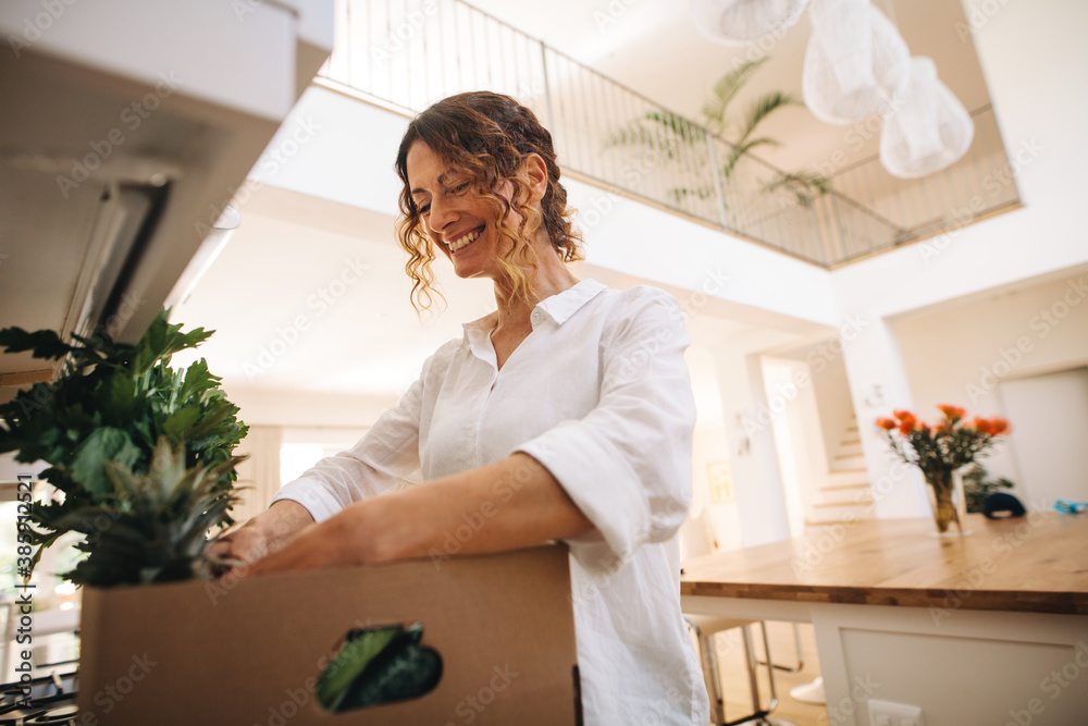 Smiling woman unpacking groceries