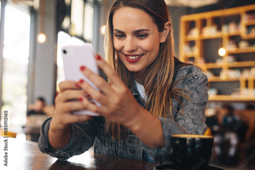 Female texting on her mobile phone at cafe