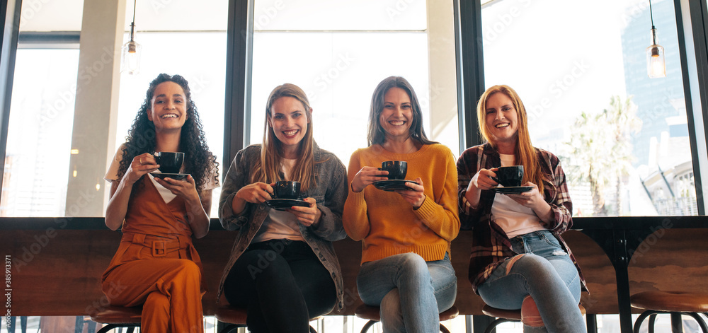 Girls group enjoying coffee in cafe