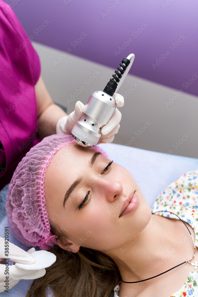 A professional cosmetologist makes facial procedures in a beauty salon. Cosmetological innovations. 