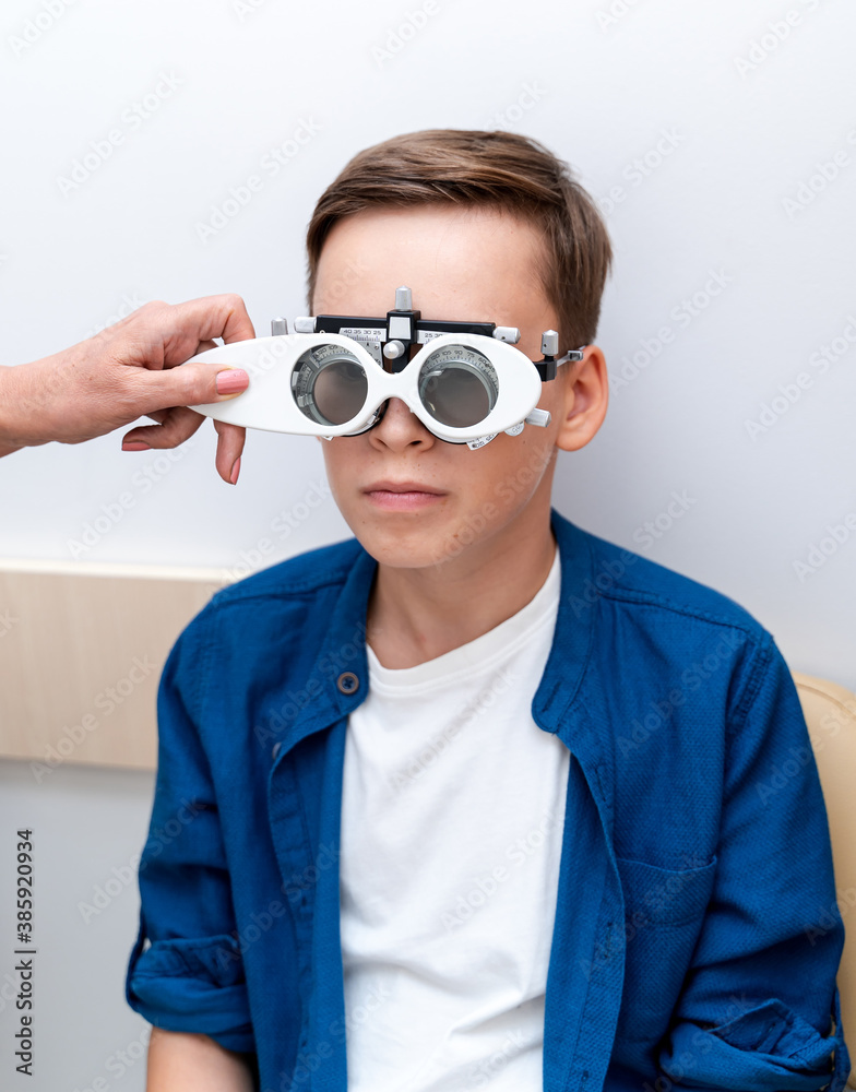 Portrait of boy wearing corrective glasses with replaceable lenses. Ophthalmology clinic.