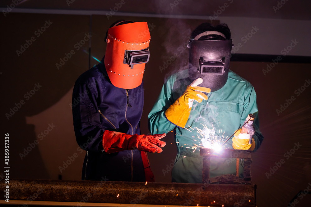 Metal welding steel works using electric arc welding machine to weld steel at factory. Metalwork man