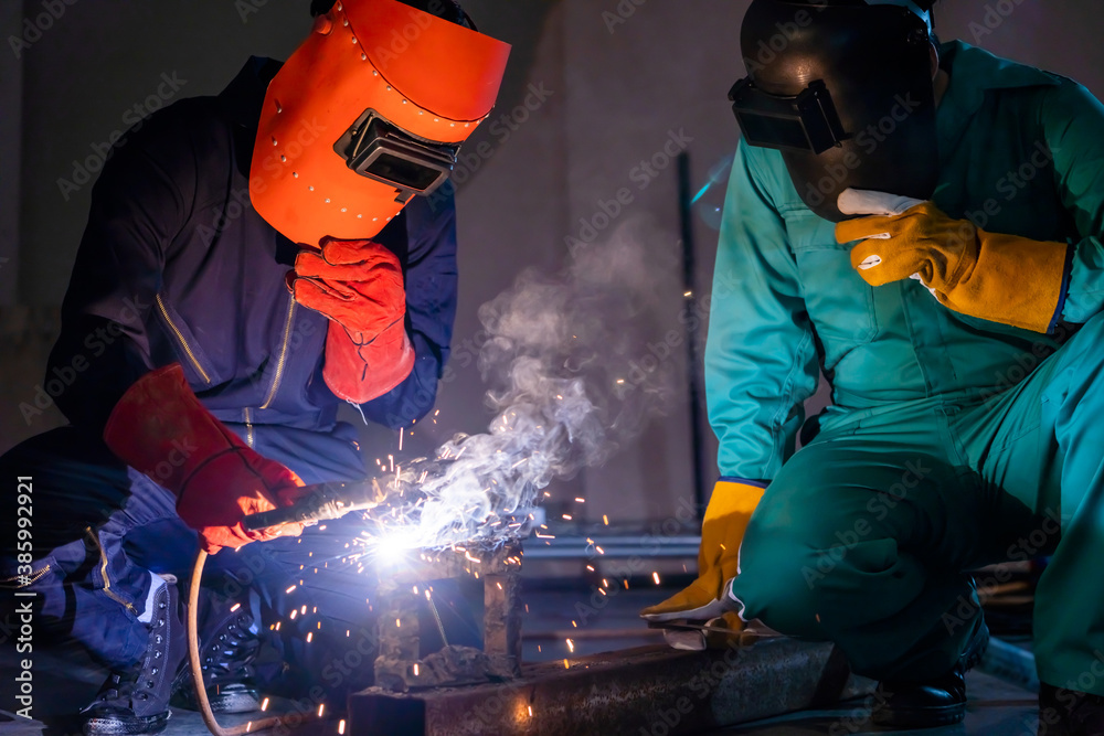 Metal welding steel works using electric arc welding machine to weld steel at factory. Metalwork man