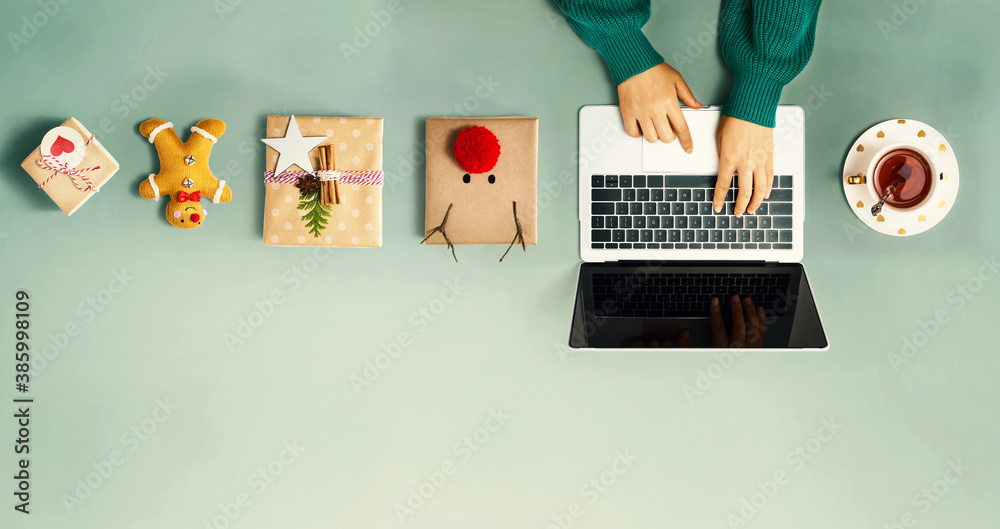 Christmas giftboxes with person using a laptop computer - overhead view