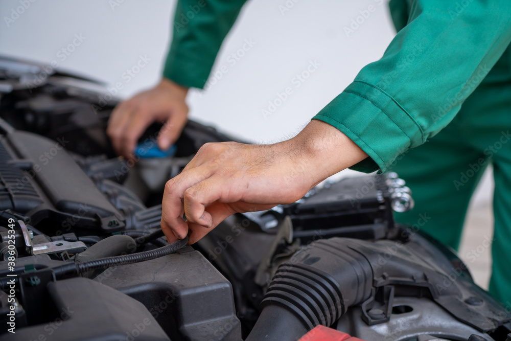 Professional mechanic hand providing car repair and maintenance service in auto garage. Car service 