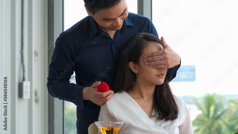 Romantic couple giving gift to lover at restaurant . Happy couple lifestyle .