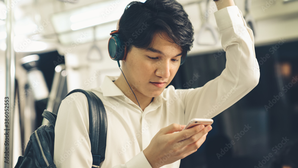 Businessman using mobile phone on public train . Urban city lifestyle commuting concept .