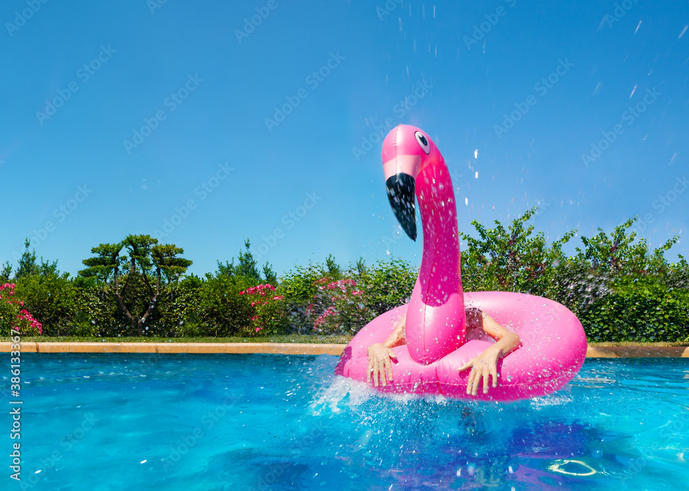 Funny photo of inflatable pink flamingo and child hands inside looking like very surprised bird in t