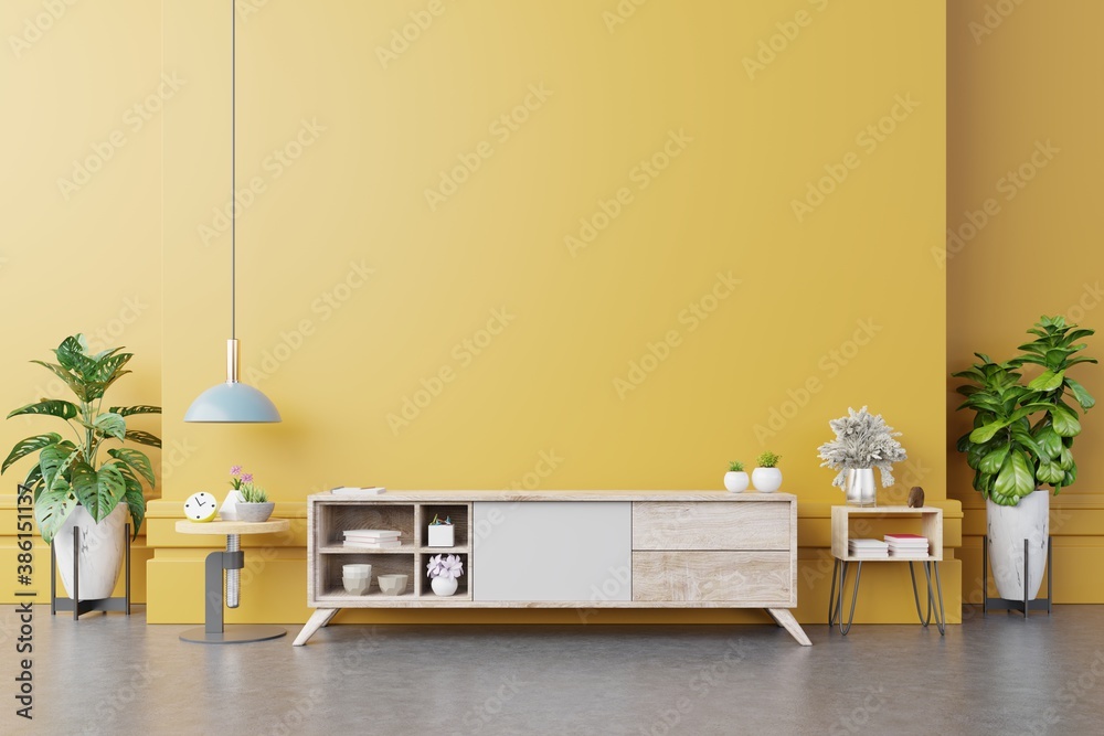 Cabinet TV in modern living room with lamp,table,flower and plant on yellow wall background.