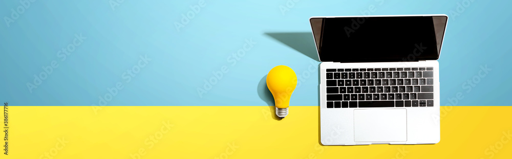 Laptop computer with a yellow light bulb from above