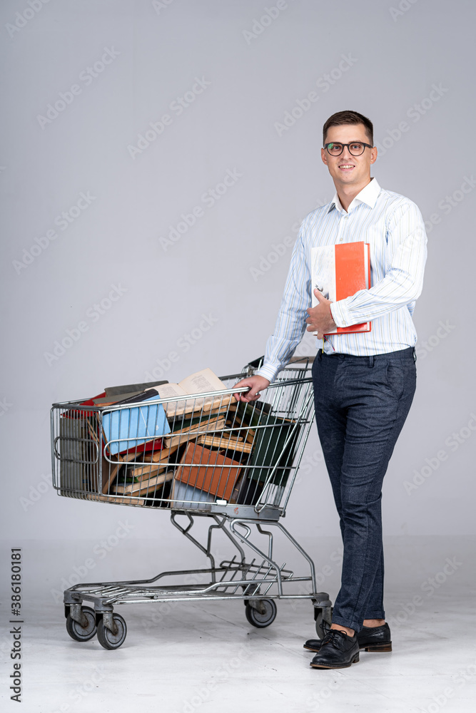 Hard working young man with many books in pushcart. Reseiving knowledge in library. Study hard. Hand