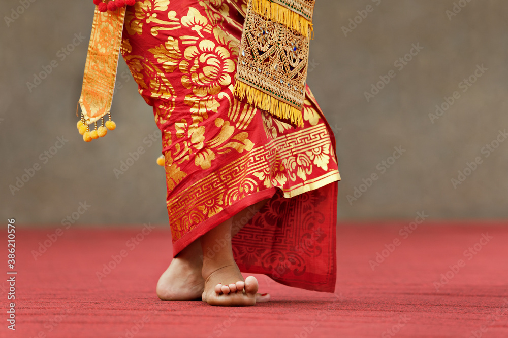 Asian travel background. Beautiful Balinese dancer woman in traditional Sarong costume dancing Legon