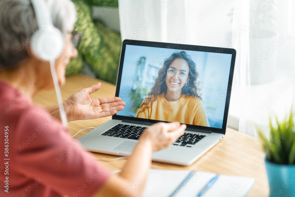 Senior woman is using laptop for conversation with daughter