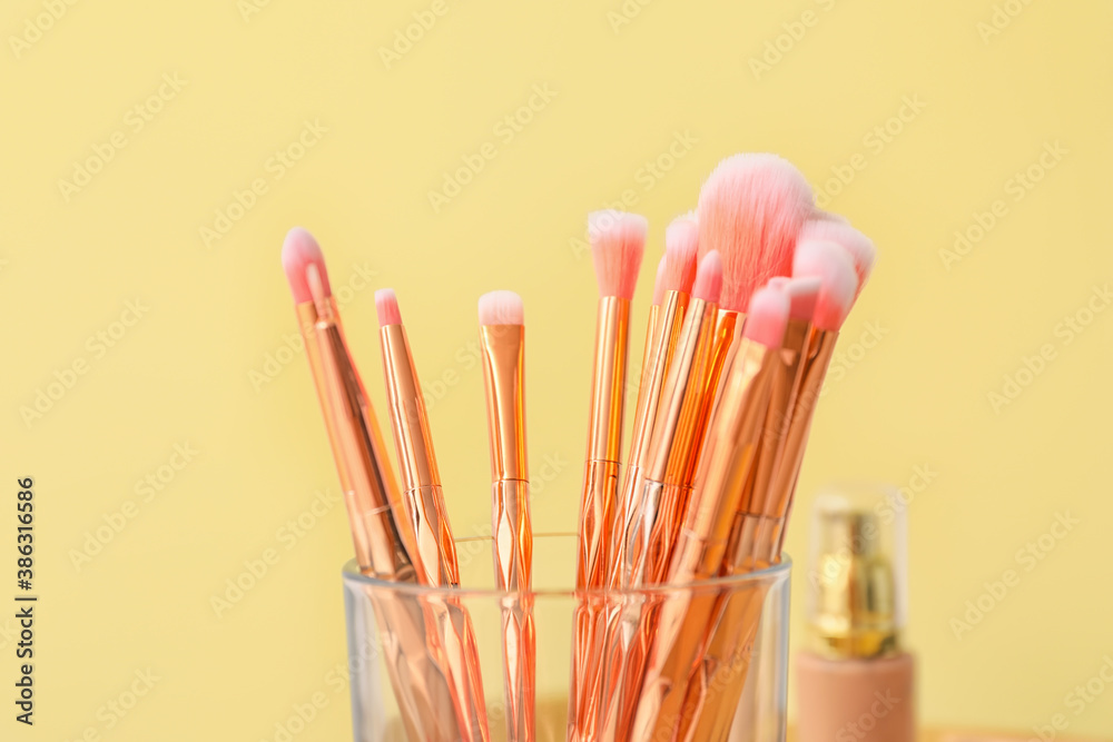 Set of makeup brushes on color background, closeup