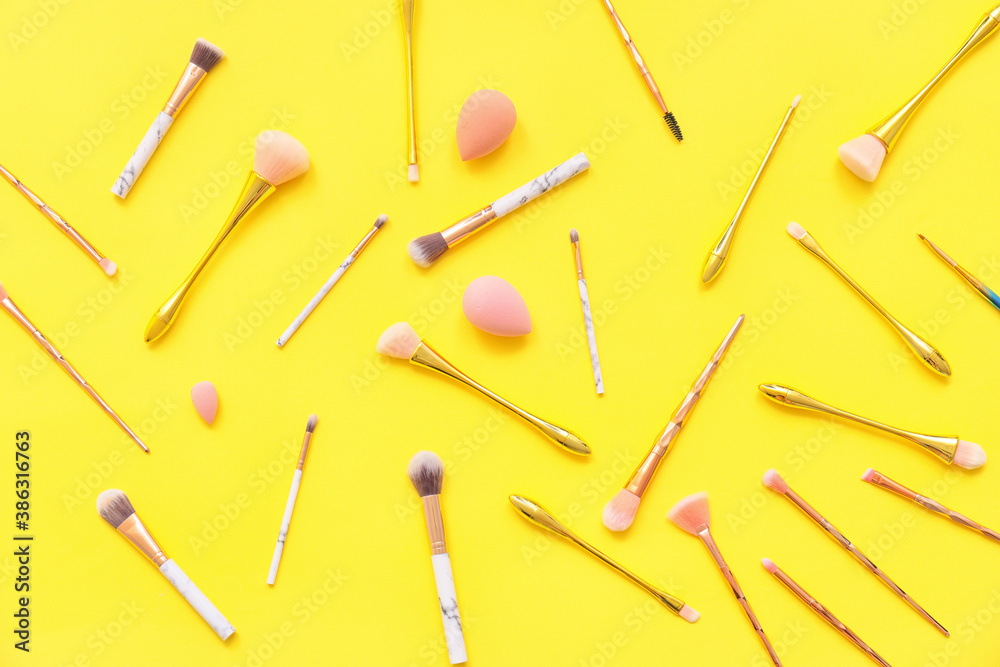 Set of makeup brushes with sponges on color background