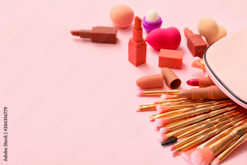 Set of makeup brushes with decorative cosmetics on color background