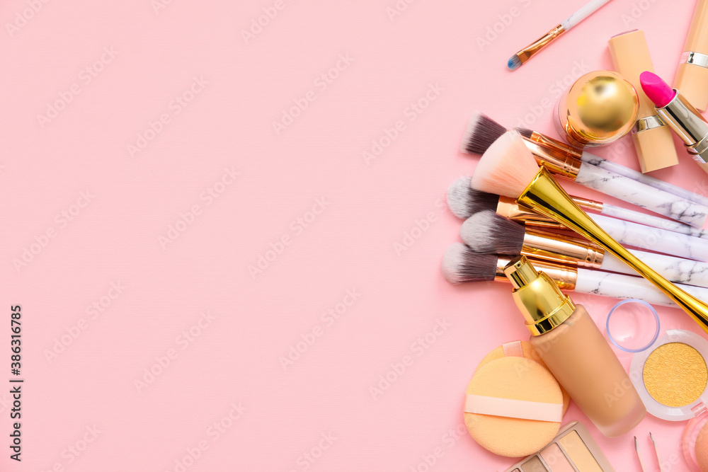 Set of makeup brushes with decorative cosmetics on color background