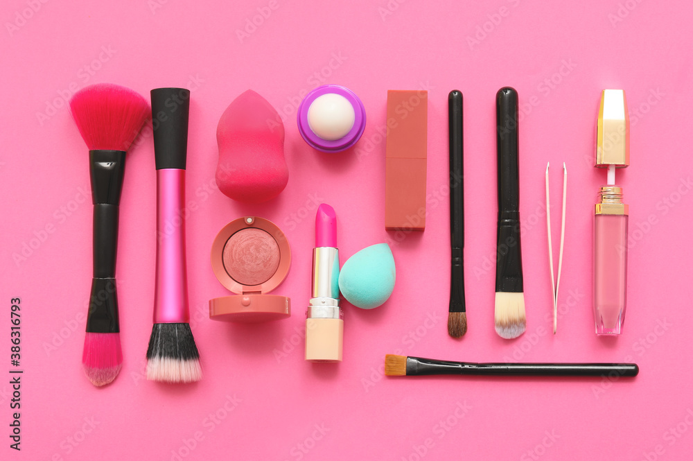 Set of makeup brushes with decorative cosmetics on color background