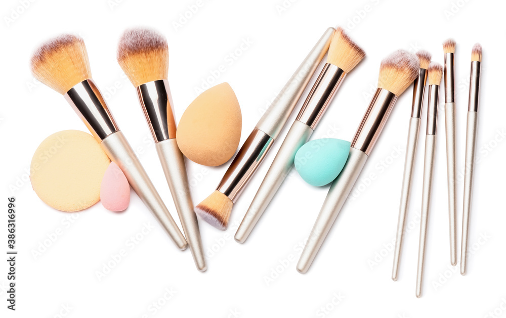 Set of makeup brushes with sponges on white background