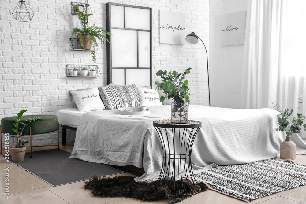 Interior of modern stylish bedroom with shelves and houseplants