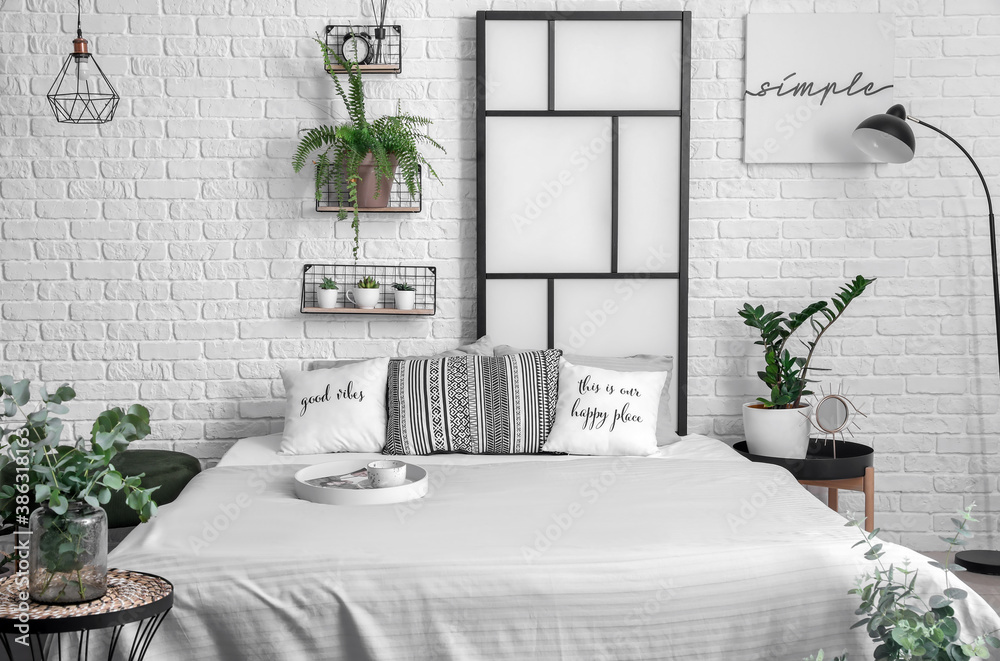 Interior of modern stylish bedroom with shelves and houseplants