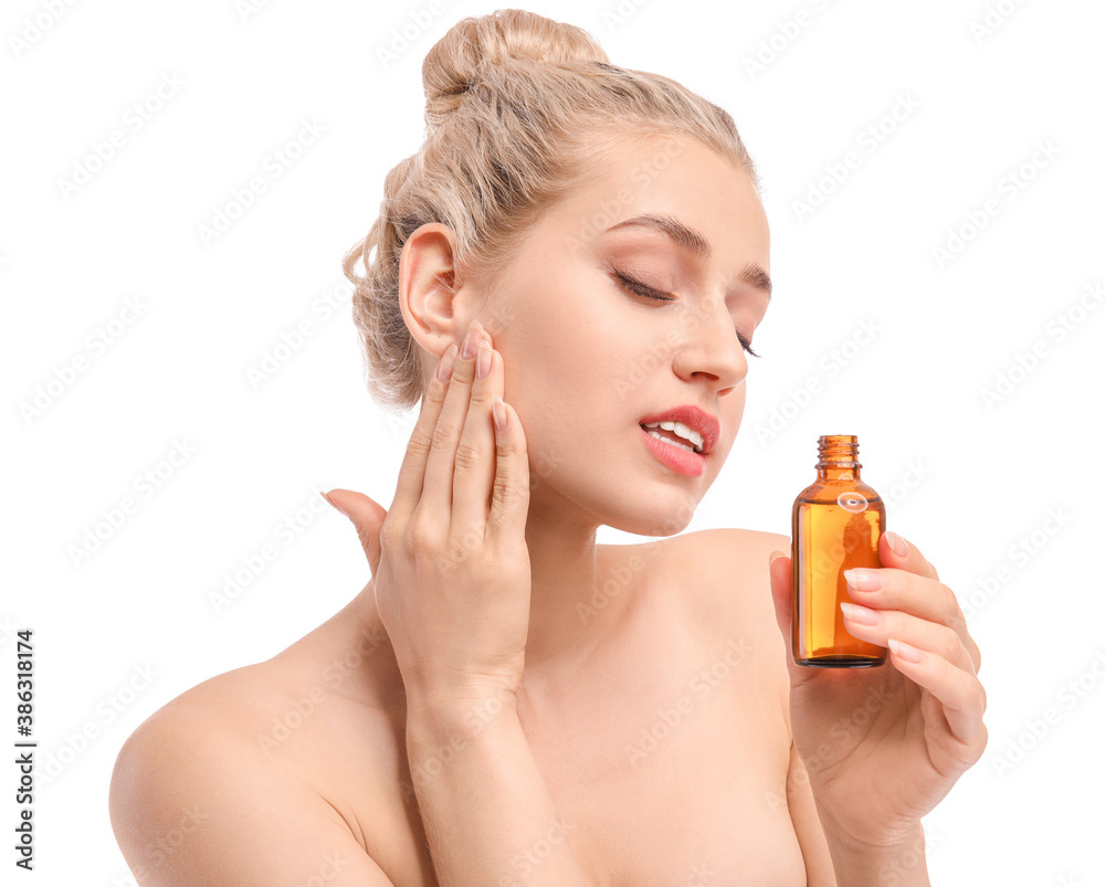 Beautiful young woman with cosmetic oil on white background