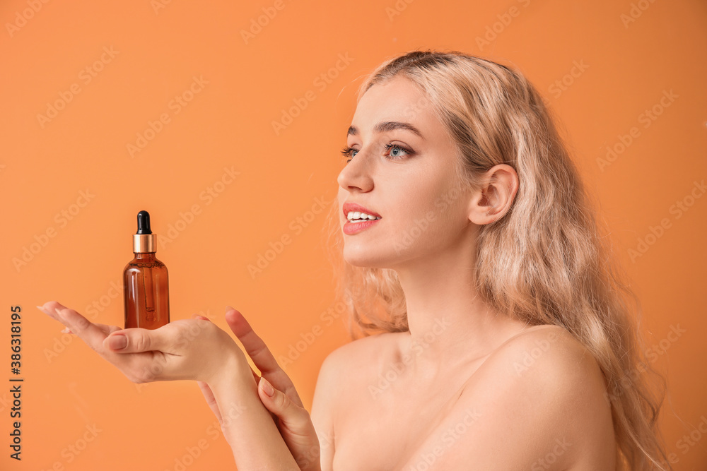 Beautiful young woman with cosmetic oil on color background