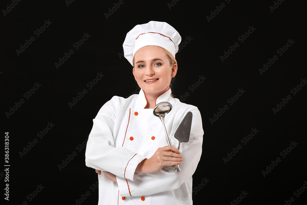 Mature female chef on dark background