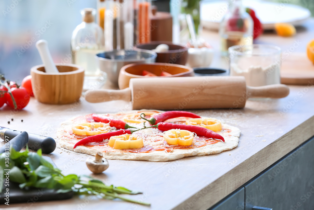 Raw pizza on kitchen table