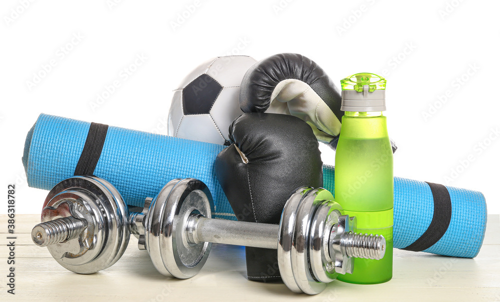 Set of sport equipment on table against white background