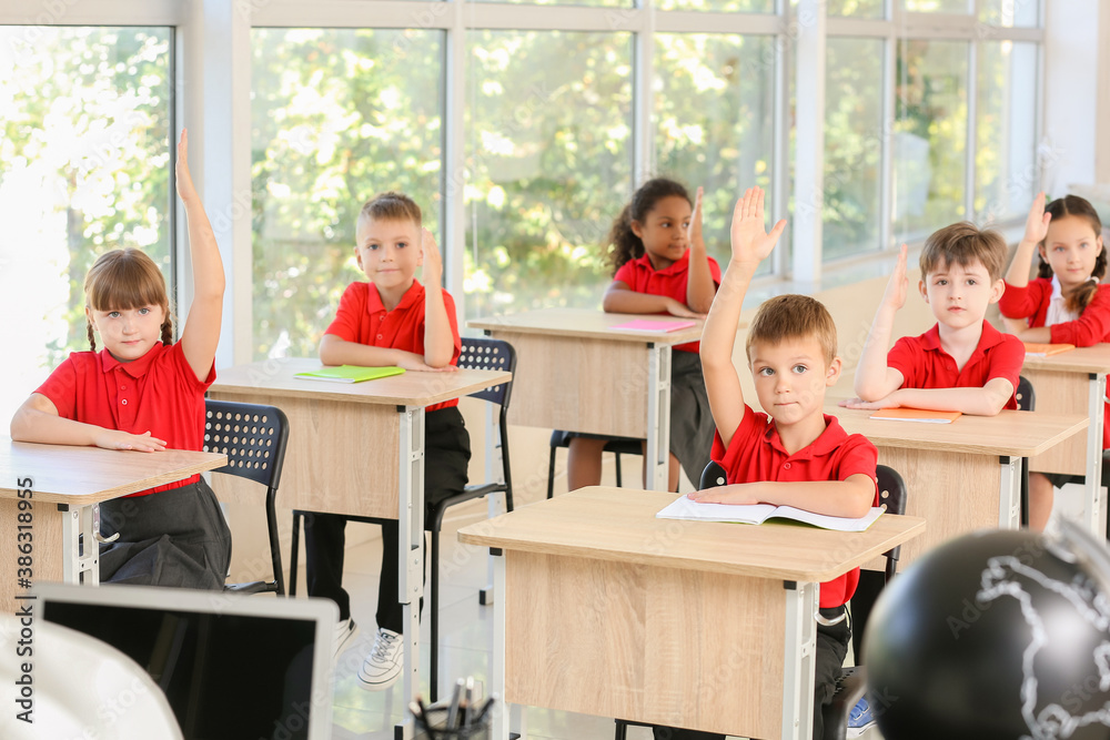 Cute pupils during lesson in classroom