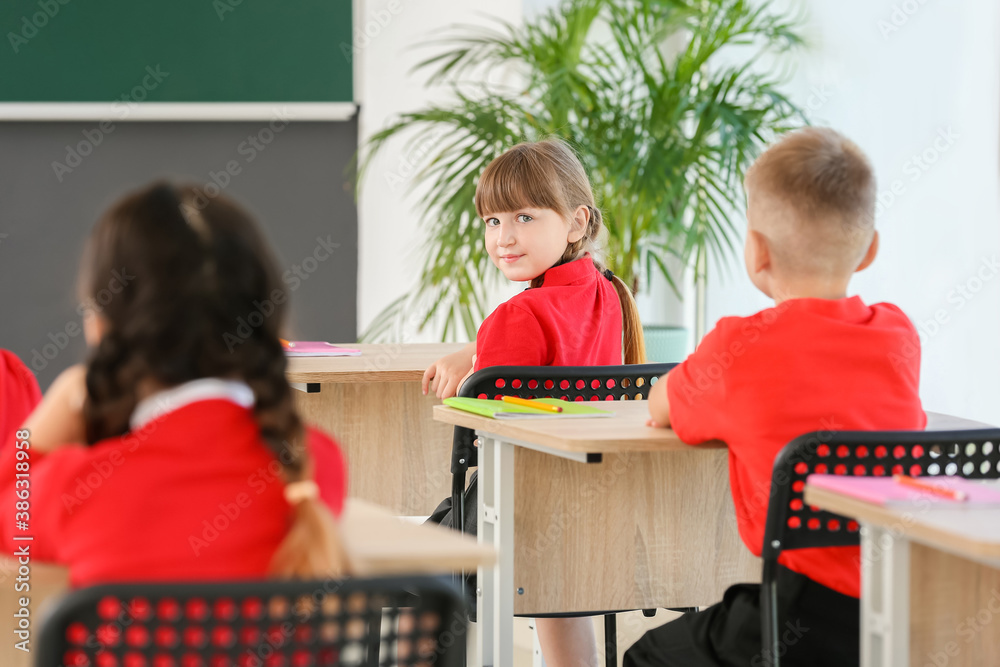 Cute pupils during lesson in classroom