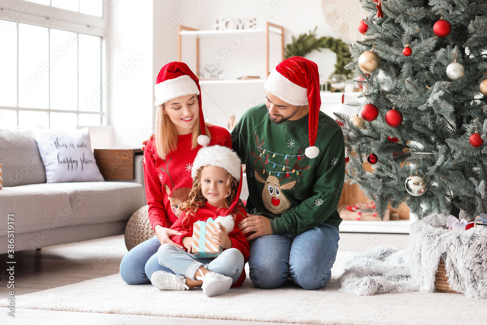 Young family with Christmas gift at home