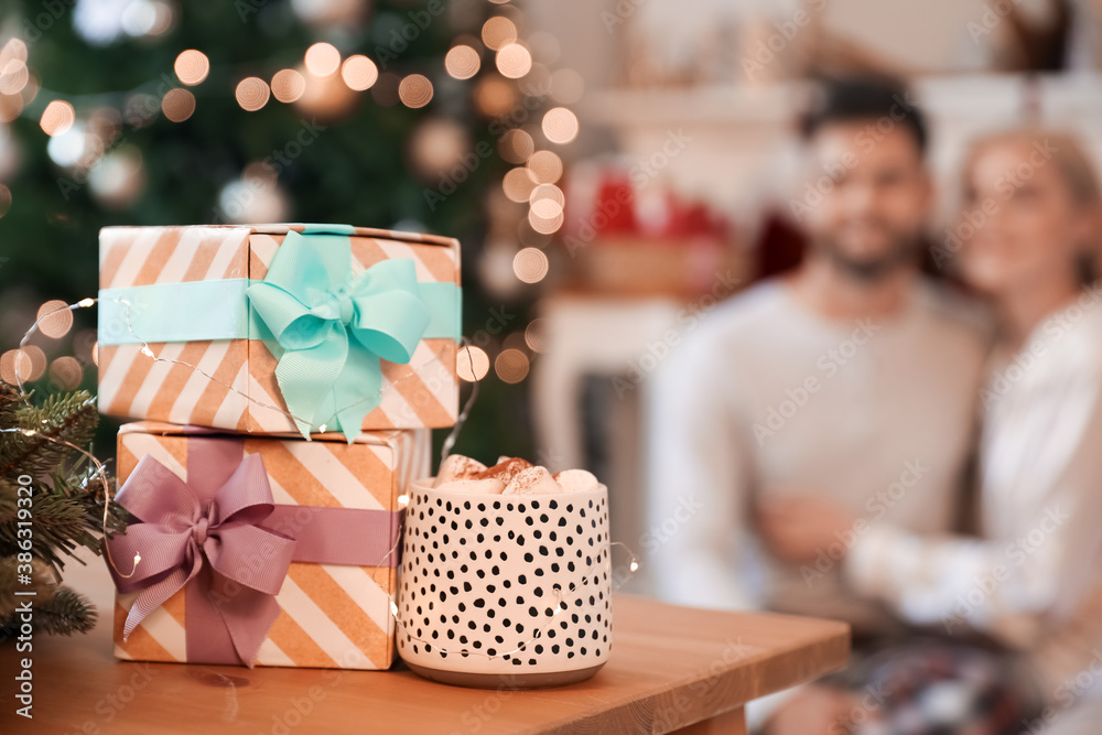 Christmas gifts with cup of hot cacao drink on table in room