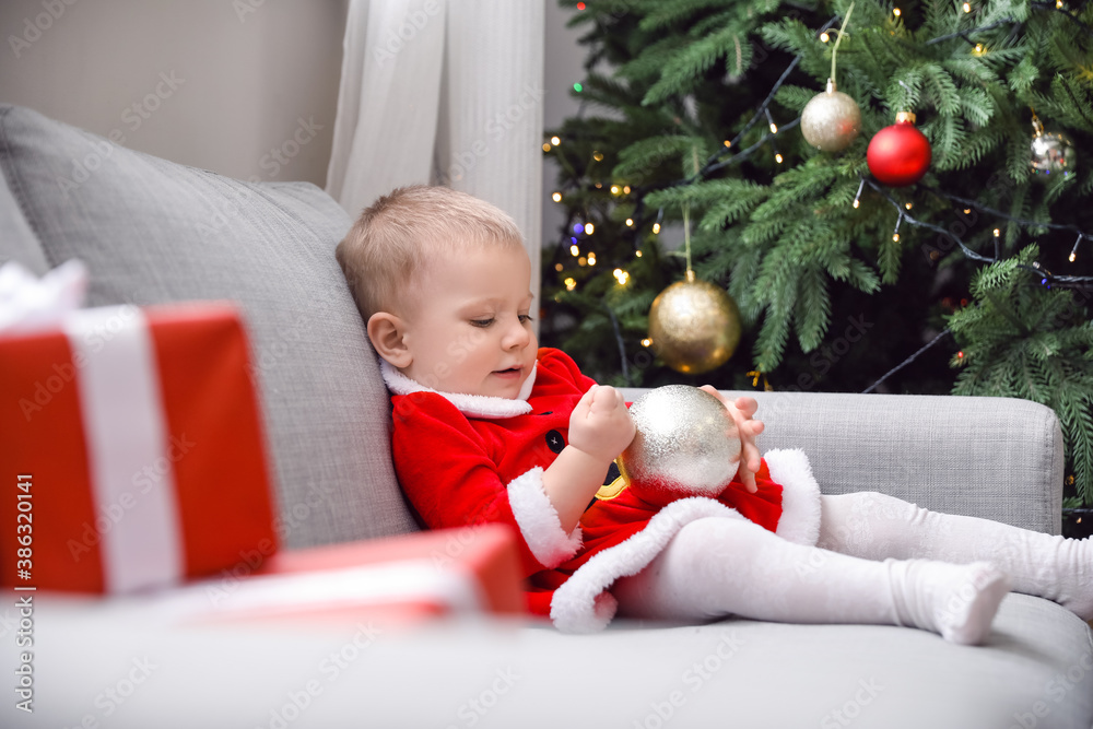 Cute little baby in Santa costume at home on Christmas eve