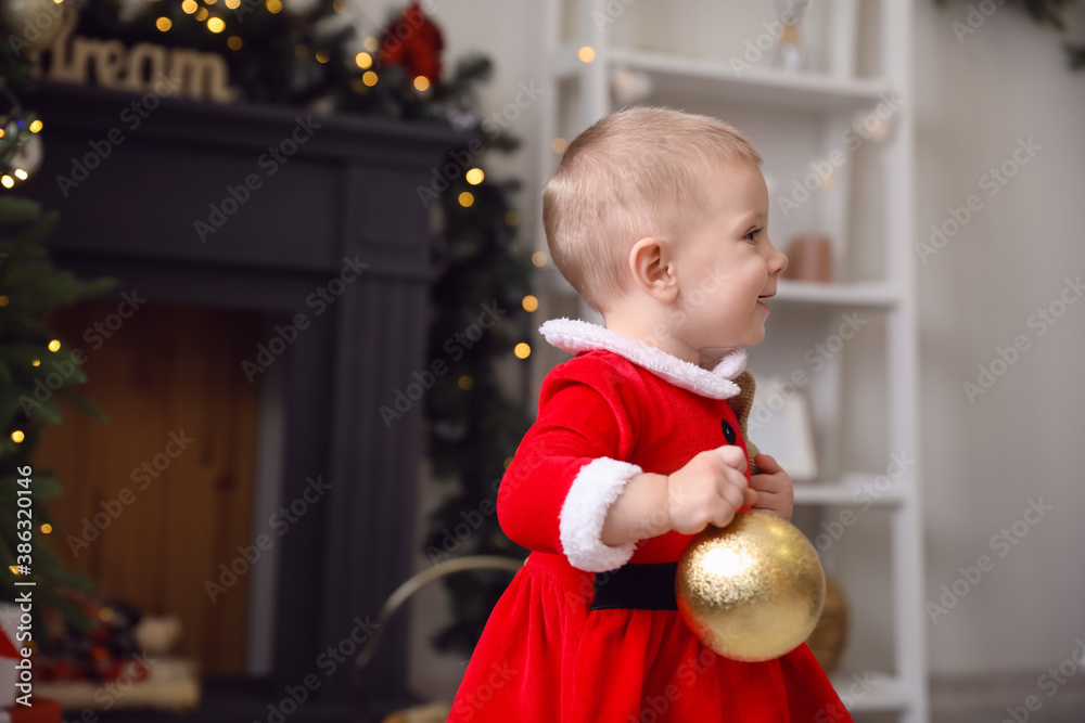 Cute little baby in Santa costume at home on Christmas eve