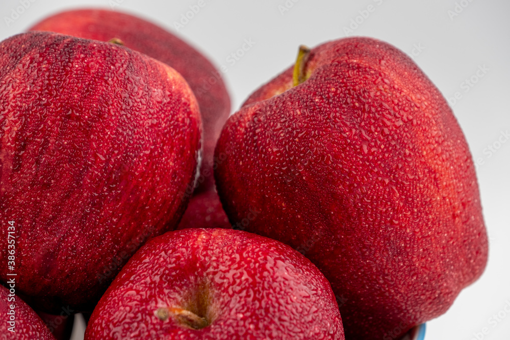 Close up of pile of red apple with clear water drop on 
shell surface texture pattern isolated, whit