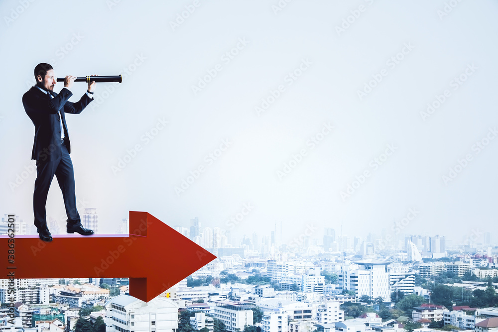 Businessman standing on red arrow and using binoculars