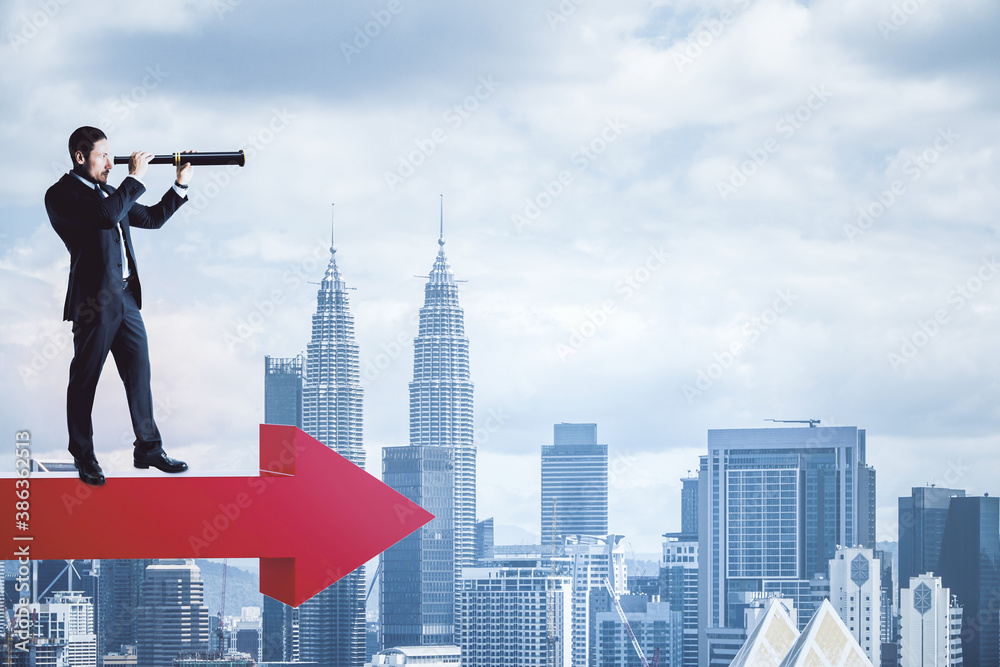 Businessman standing on red arrow and looking on city.