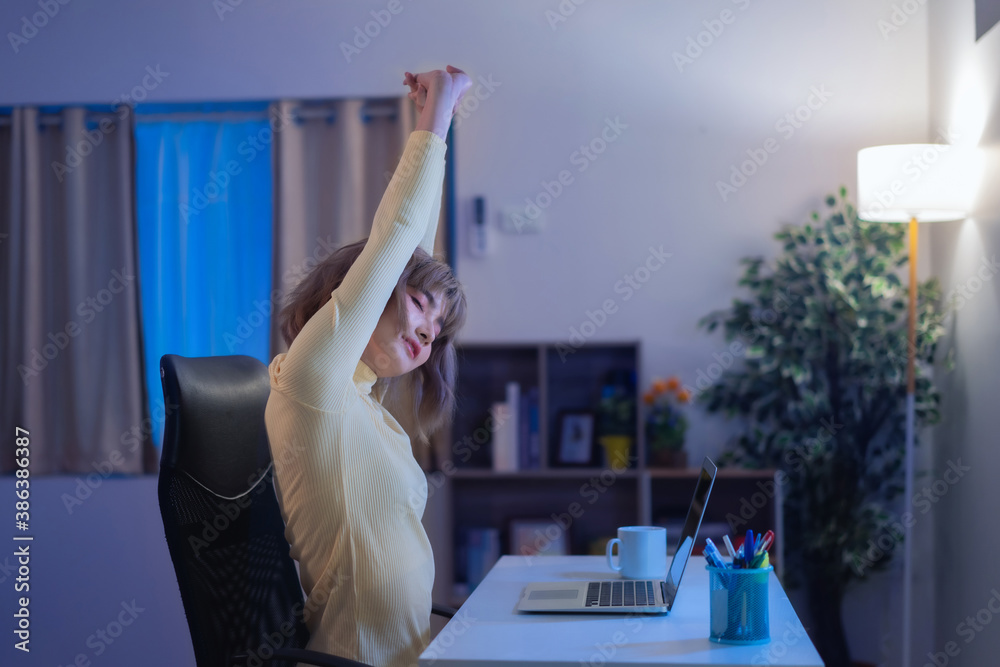 Asian woman, she stretches and relaxes, she works at night.