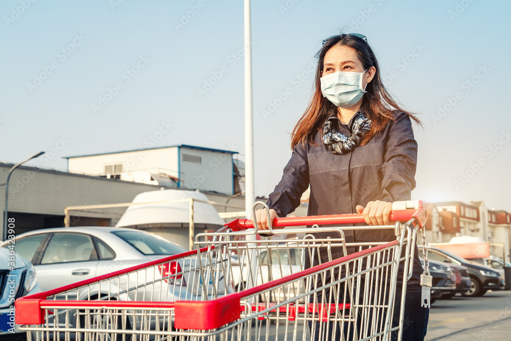 女子在超市停车场推车购物