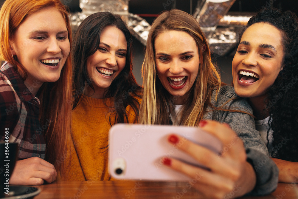 Friends having fun at cafe taking a selfie